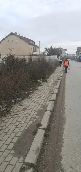 🦺Punonjësit e NPL "Ambienti" kanë marr aksion për lirimin e trotuarit nga barishtet dhe mbetjeve tjera në Rrugën "Naim Beka ".