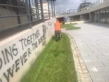 Pastrimi dhe kositja e barit në hapsirat e gjelbërta te nënkalimi i qytetit.